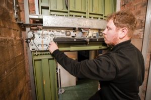 engineer working on car top control and doors. lift maintenance